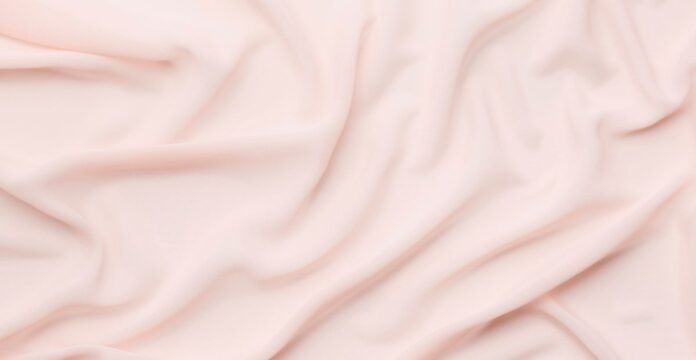 “Close-up of soft, pale pink fabric with gentle folds and draping.” Vegan Winter Fabric Explained: