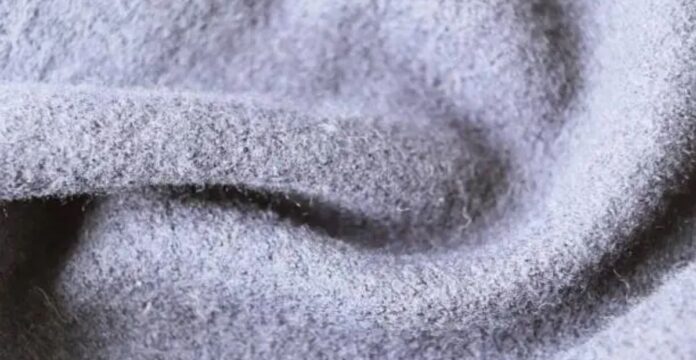 “Close-up photo of soft, light gray wool fabric with a fuzzy texture.” High-Density Wool Fabric: