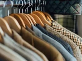 A rack of hanging jackets and coats on wooden hangers, showing a variety of fabrics and colors.Luxury Winter Jackets: