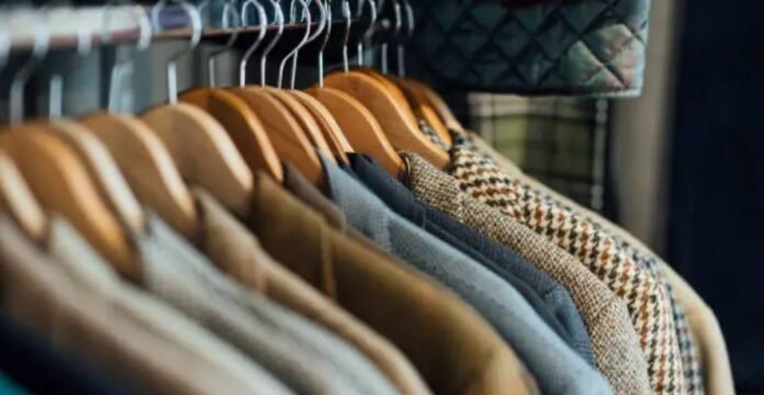 A rack of hanging jackets and coats on wooden hangers, showing a variety of fabrics and colors.Luxury Winter Jackets: