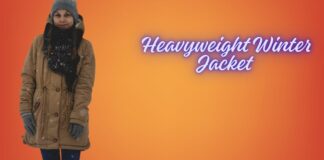 Heavyweight Winter Jacket for Snow: Ultimate Cold Protection "Woman standing in the snow wearing a tan mid-length winter jacket, blue jeans, gray gloves, a knit hat, and a scarf. Orange gradient background with the text 'Heavyweight Winter Jacket'." Heavyweight Winter Jacket for Snow: