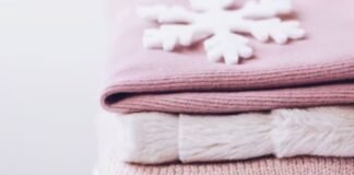 Sustainable Winter Fabrics for 2025: Eco-Friendly Warmth Now Close-up of soft winter fabrics in pastel pink tones, stacked with a folded knit sweater on top. Sustainable Winter Fabrics for 2025:
