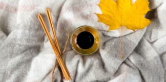 Soft Winter Fabrics for Sensitive Skin: Cozy & Itch-Free Now A cozy flat lay: a cup of coffee, a few cinnamon sticks tied together, and a yellow autumn leaf placed on a soft gray blanket.Soft Winter Fabrics for Sensitive Skin: