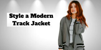 Style a Modern Track Jacket for Effortless Everyday Fashion. A woman wearing a modern gray track jacket stands against a light gray background with spotlights; bold text on the left reads 'Style a Modern Track Jacket.