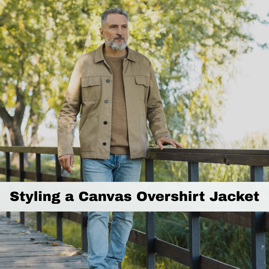 Canvas Overshirt Jacket: Durable Style for Everyday Wear 4 A mature man with a gray beard stands outdoors on a wooden railing, wearing a tan canvas overshirt jacket over a brown sweater and light blue jeans.
