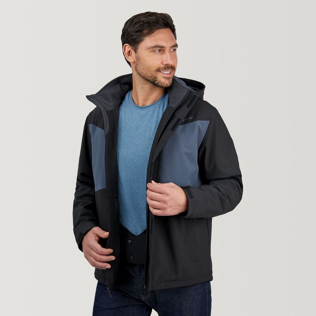 A man wearing a black and blue storm jacket over a blue shirt, standing against a light background, zipping up the front with a hood.Storm Jacket for Men