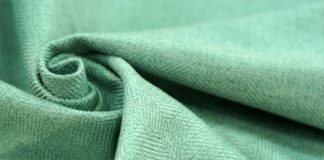 Brushed Grade C Cashmere Fabric Explained Brushed Grade C Cashmere Fabric Close-up of light green brushed cashmere fabric with a twill weave, folded into a swirl on the left.