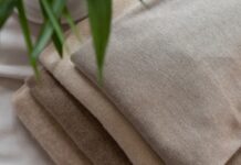 Brushed Pure Cashmere Fabric Guide: Soft Luxury Explained Brushed Pure Cashmere Fabric Guide Close-up of a stack of brushed cashmere fabrics in beige and brown tones, folded neatly on a white surface with blurred green plant leaves in the corner.