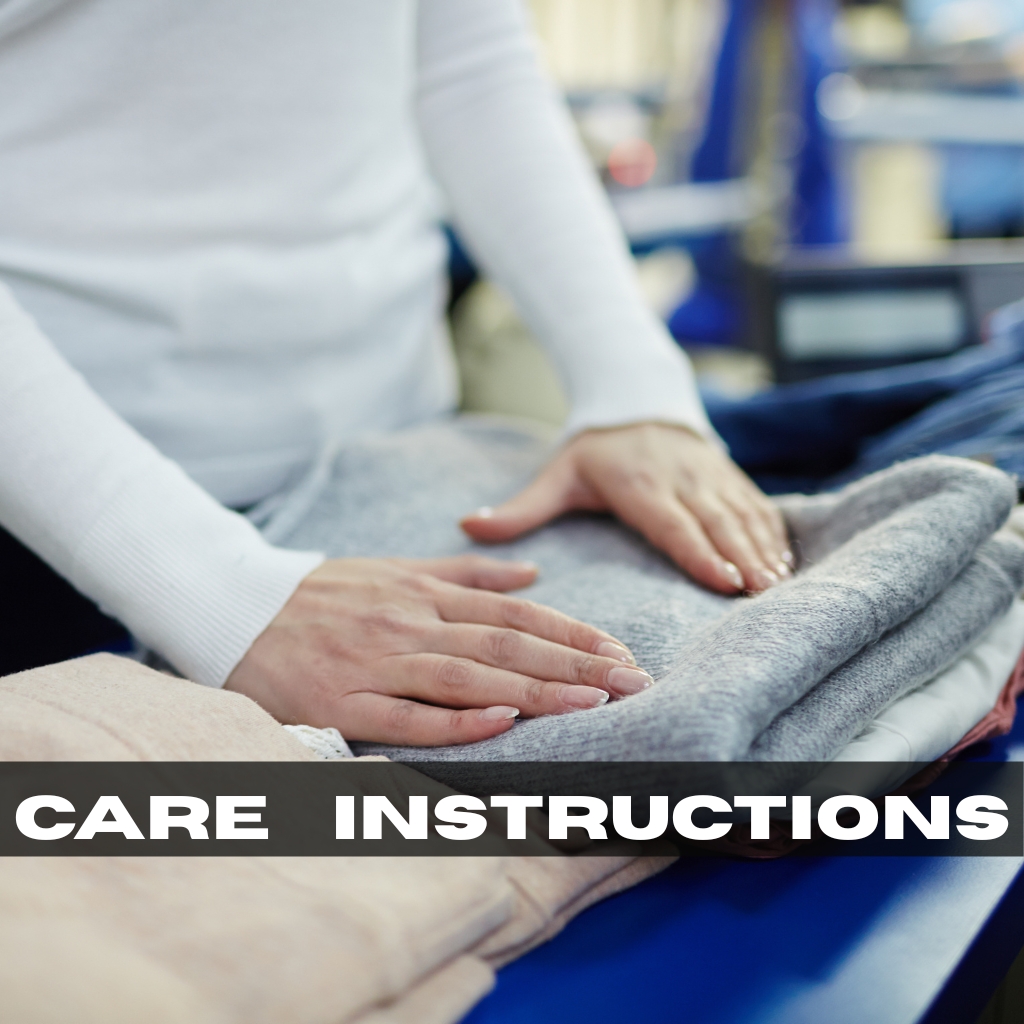 Abstract Graphic Hoodies: Bold Street Style Guide 6 A person in a white sweater is carefully folding a stack of freshly laundered clothes on a blue surface, smoothing a gray sweater atop other folded garments.