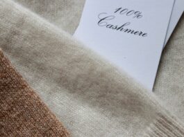 Cashmere Blended Fabric: Luxury Comfort With Everyday Durability Cashmere Blended Fabric Close-up view of stacked cashmere fabrics in brown and beige tones, with a white tag reading '100% Cashmere' partially visible.