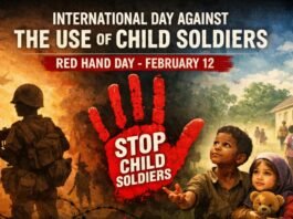 A somber anti-war poster showing two children looking worried in the foreground, with a soldier aiming a weapon on the left and helicopters in the sky. A large red handprint with the words “STOP CHILD SOLDIERS” dominates the center. Barbed wire in the foreground, a group of children walking toward a building in the background, and a blue and smoky sky convey urgency and danger. Day Against the Use of Child Soldiers