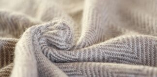 Double-Ply Grade B Cashmere: Warm & Durable Double-Ply Grade B Cashmere Close-up of folded double-ply cashmere in beige and light gray with a chevron/herringbone pattern.