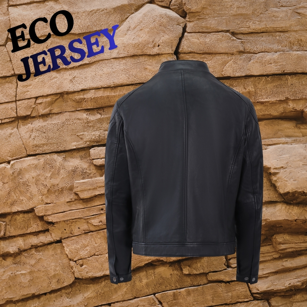 A matte black leather jacket is shown from the back, hanging against a textured stone wall. The jacket features a straight collar and clean, minimalist seams, with buttoned cuffs. The words “ECO JERSEY” appear in the upper left in black and blue, overlaid on the image.