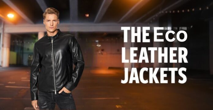 A man wearing a black leather jacket and dark jeans stands in an urban, dimly lit setting. The image features a bold text overlay reading “THE ECO LEATHER JACKETS.”