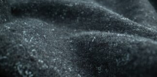 Felted Pure Cashmere Fabric: Features, Uses, and Benefits Felted Pure Cashmere Fabric Close-up of dark gray felted cashmere fabric with small white fibers or lint attached; fabric is draped with soft, fuzzy texture.