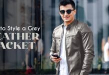 Grey Leather Jacket – Stylish & Versatile Outerwear for Every Look A man wearing a grey leather jacket and sunglasses stands in front of a glass building, holding a smartphone. The words 'How to Style a Grey Leather Jacket' appear on the left.