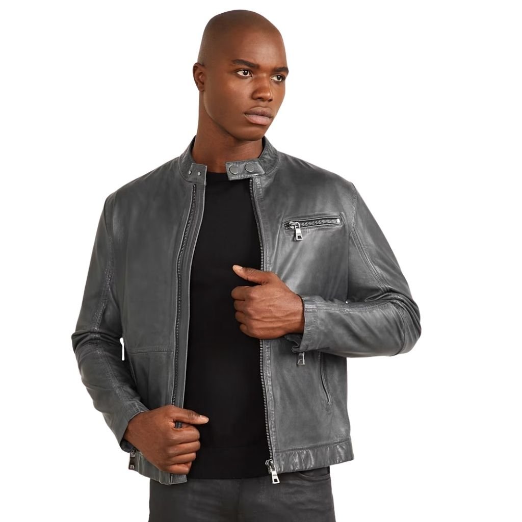 Grey Leather Jacket – Stylish & Versatile Outerwear for Every Look 4 A bald man with dark skin wearing a gray leather jacket over a black shirt. The jacket features a stand-up collar, a zippered chest pocket, and a zipper front; it is partially unzipped.