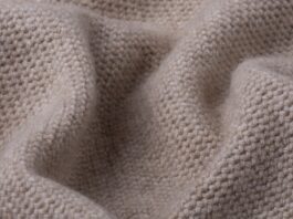 Lightweight Pure Cashmere Fabric Close-up of a lightweight, light-brown knitted cashmere fabric with a dense, uniform knit pattern and soft folds.