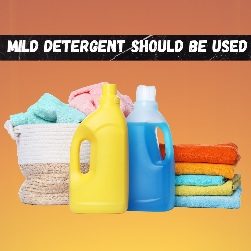 Vintage Zip Hoodie: Classic Retro Streetwear Style 6 Two detergent bottles, one yellow and one blue, placed in front of a stack of colorful towels in orange, turquoise, and pink, with a woven basket and an orange gradient background.