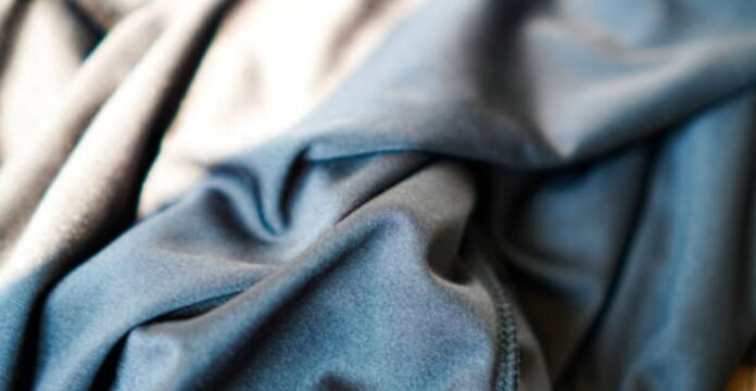 Close-up of folded blue-grey fabric with soft texture and visible seam on the right; light-to-dark color gradient.What Is Cryo Comfort Winter Fabric?