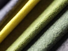 Alt text: Close-up of layered, textured fabric in muted greens with a bright yellow strip, showcasing soft, fuzzy material. Why Alpine Therm Winter Fabric?