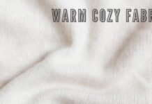 Ever Warm Cozy Fabric Guide: Stay,Warm Stylish & Comfortable Alt text: A close-up view of cream-colored fabric with soft folds and shadows, conveying a warm, cozy texture. The text "WARM COZY FABRIC" appears across the top in bold, shadowed lettering. Ever Warm Cozy Fabric Guide: