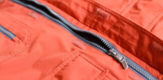 Storm Warm Insulation Fabric: Ultimate Winter Warmth Guide Close-up of an orange winter coat with a partially unzipped gray-lined zipper; visible pockets and Velcro closures along the fabric.Storm Warm Insulation Fabric: