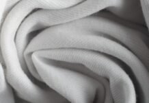 Frost Flex Stretch Thermal Fabric: Warmth Meets Flexibility Alt text: Close-up of white woven fabric in soft folds, showing fine ribbed texture and diffused shadows. Frost Flex Stretch Thermal Fabric:
