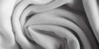 Frost Flex Stretch Thermal Fabric: Warmth Meets Flexibility Alt text: Close-up of white woven fabric in soft folds, showing fine ribbed texture and diffused shadows. Frost Flex Stretch Thermal Fabric: