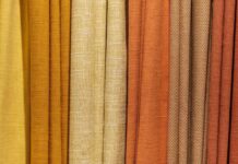 Warm Aura Fabric Explained:Why It’s Perfect for Cold Weather Alt text: Close-up of vertical fabric drapes in a gradient from light yellow to dark orange, showing a mix of smooth and textured surfaces. Warm Aura Fabric Explained: