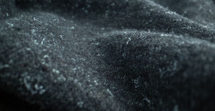 Alt text: Close-up of dark, textured fabric likely from a heavy winter coat, showing a fuzzy, felt-like surface. Winter Shield Active Fabric: