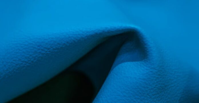 Alt text: Close-up of turquoise folded material (leather or fabric) with light highlighting the texture on the top and right, and shadow in the left fold. What Is Arctic Fusion Tech Fabric?