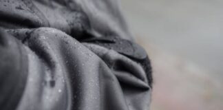 Climate Lock Winter Fabric: The Ultimate Winter Protections Close-up of dark gray fabric with water droplets clinging to its surface; blurred background. Climate Lock Winter Fabric: