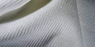 What Is Heat Retain Pro Weave Fabric? Uses & Benefits Guide Alt text: Close-up of a creamy white knit fabric with a ribbed pattern, showing folds and soft shadows that highlight texture. What Is Heat Retain Pro Weave Fabric?