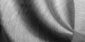Alpine Silk Shield Fabric: Premium Comfort for Harsh Winters Alt text: Close-up of a draped linen fabric in grayscale, showing visible weave and soft lighting that highlights folds and curves for a textured, abstract effect. Alpine Silk Shield Fabric: