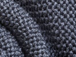 "Close-up of densely textured dark gray knit fabric with small geometric patterns and deep folds." Glacier Soft Elite Knit Explained: