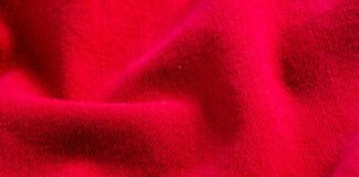 Polar Velvet WarmTech Fabric Explained: Warmth Meets Luxury Close-up of vibrant red textile with soft folds and a textured surface creating shadows and highlights. Polar Velvet WarmTech Fabric Explained: