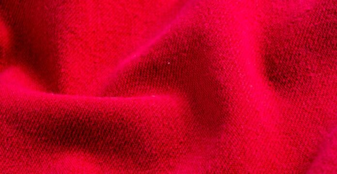 Close-up of vibrant red textile with soft folds and a textured surface creating shadows and highlights. Polar Velvet WarmTech Fabric Explained: