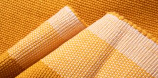 Hyper Cool Performance Weave Explained: Features & Benefits Close-up of a woven fabric in golden yellow and white, showing texture and folded layers. Hyper Cool Performance Weave Explained: