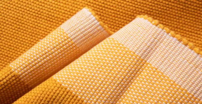 Close-up of a woven fabric in golden yellow and white, showing texture and folded layers. Hyper Cool Performance Weave Explained: