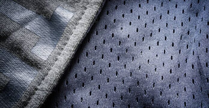 Close-up image showing two fabric textures: a gray striped knit and a blue-purple mesh with small perforations.Heat Core Insulated Sports Textile: