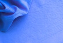 Aqua Dry Cooling Active Fabric: Beat Heat, Boost Performance Close-up of blue fabric with a textured surface, showing draped folds on the left and a taut, subtly striped area on the right.Aqua Dry Cooling Active Fabric: