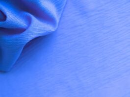 Close-up of blue fabric with a textured surface, showing draped folds on the left and a taut, subtly striped area on the right.Aqua Dry Cooling Active Fabric: