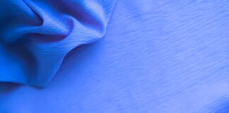 Aqua Dry Cooling Active Fabric: Beat Heat, Boost Performance Close-up of blue fabric with a textured surface, showing draped folds on the left and a taut, subtly striped area on the right.Aqua Dry Cooling Active Fabric: