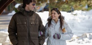 Ultra-Warm Thermal Winter Coat: Ultimate Cold-Weather Armor "A man and woman walk outdoors in a snowy landscape. The man wears a brown fur-lined hooded winter jacket and sunglasses, the woman wears a light gray fur-trimmed winter jacket with sunglasses on her head; both are smiling." Ultra-Warm Thermal Winter Coat: