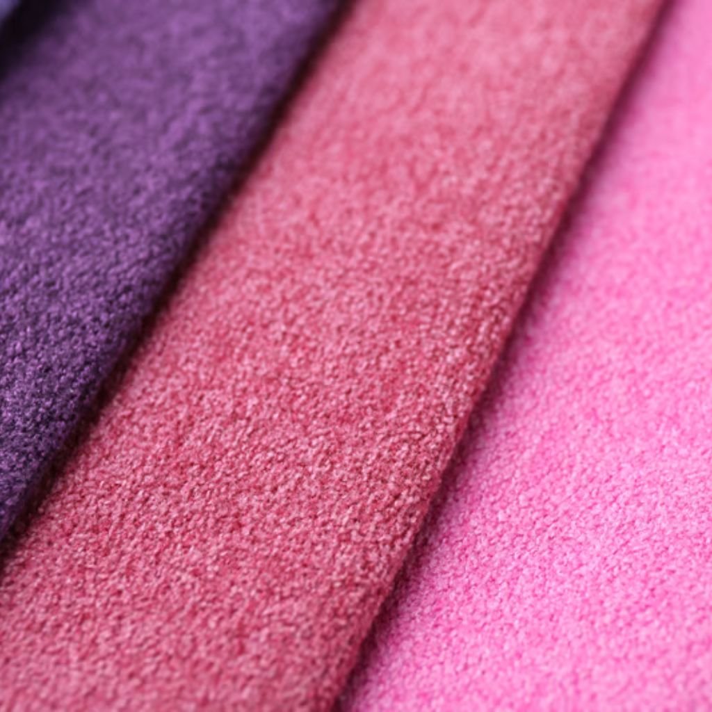 "Close-up of three overlapping plush fabrics in a color gradient from dark purple on the left to pink on the right, with a soft, inviting texture."

Velvet Warm Fabric Explained: