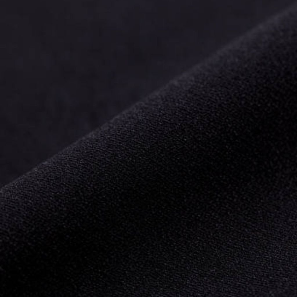 Alt text: Close-up of a dark, textured fabric with a soft, slightly raised pattern and a diagonal fold across the frame.
What Is Thermal Core Elite Fabric?