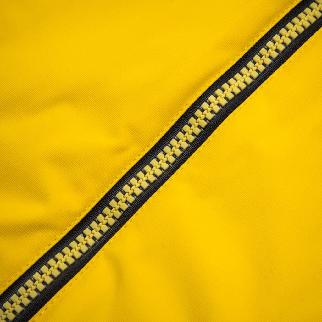 Storm Warm Insulation Fabric: Ultimate Winter Warmth Guide 9 Close-up of bright yellow fabric with a diagonal black-and-yellow zipper; the textured material and prominent zipper teeth create a dynamic, high-contrast detail.Storm Warm Insulation Fabric:
