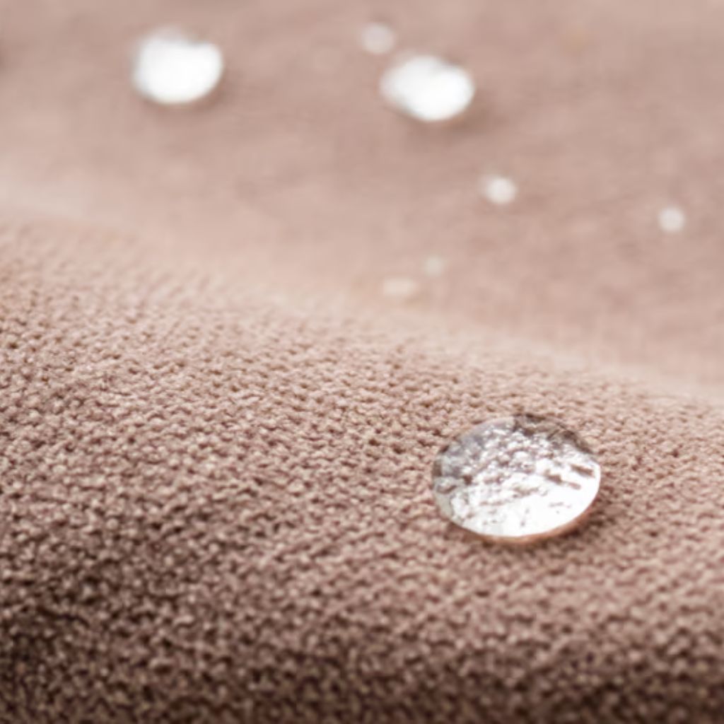 Winter Shield Active Fabric: Warm, Dry & Active Wear Guide 9 Alt text: Close-up of translucent water droplets resting on textured brown fabric with a soft, raised surface; background is blurred.Winter Shield Active Fabric: