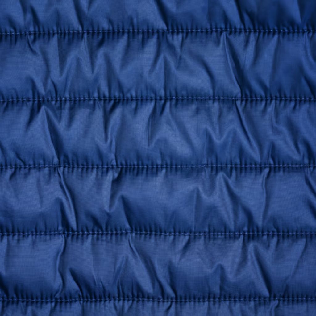 Climate Lock Winter Fabric: The Ultimate Winter Protections 8 Close-up of royal blue padded nylon fabric with horizontal channel stitching and a slight sheen.
Climate Lock Winter Fabric: